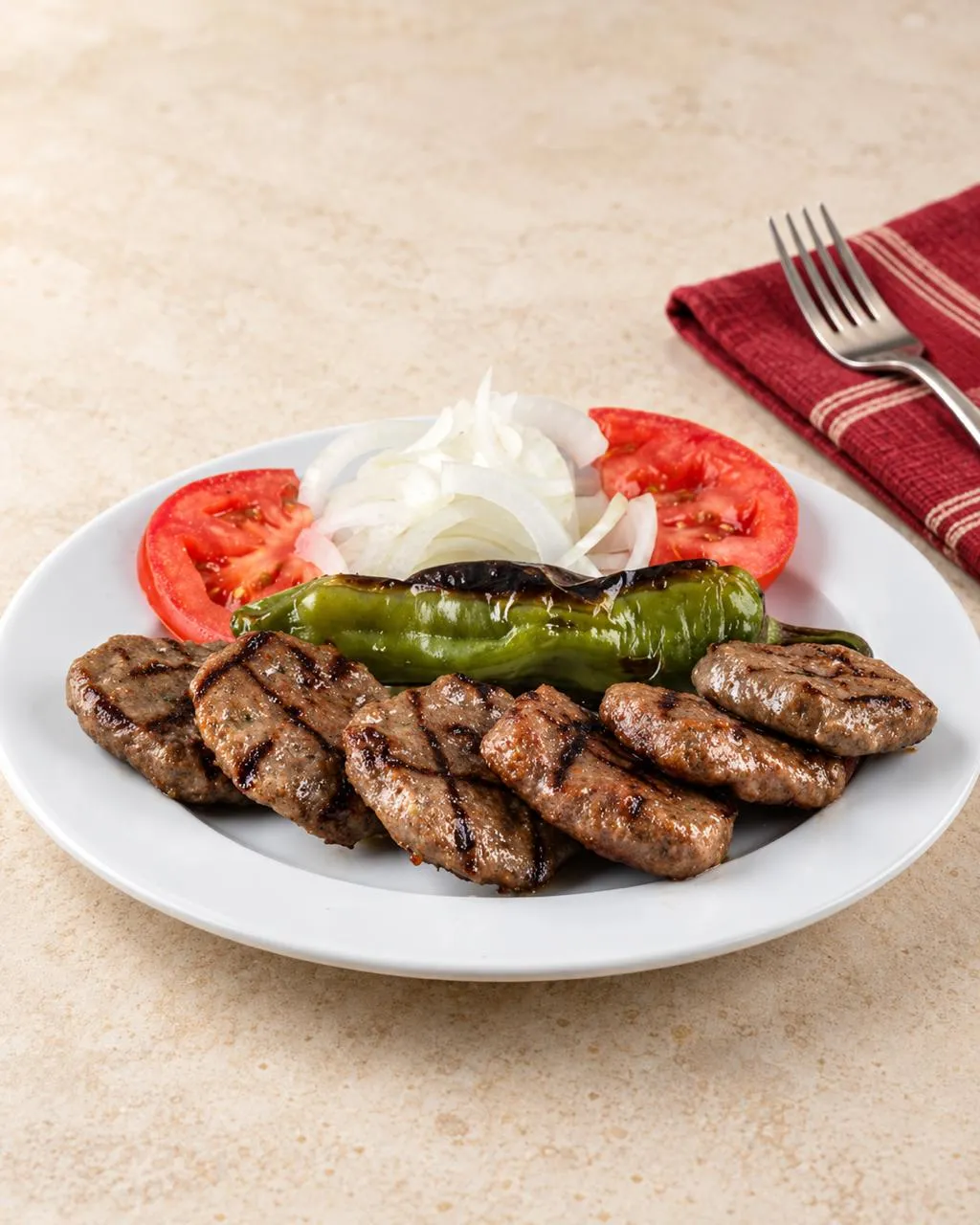 Mermer masada ızgara köfte, közlenmiş biber, domates ve soğan